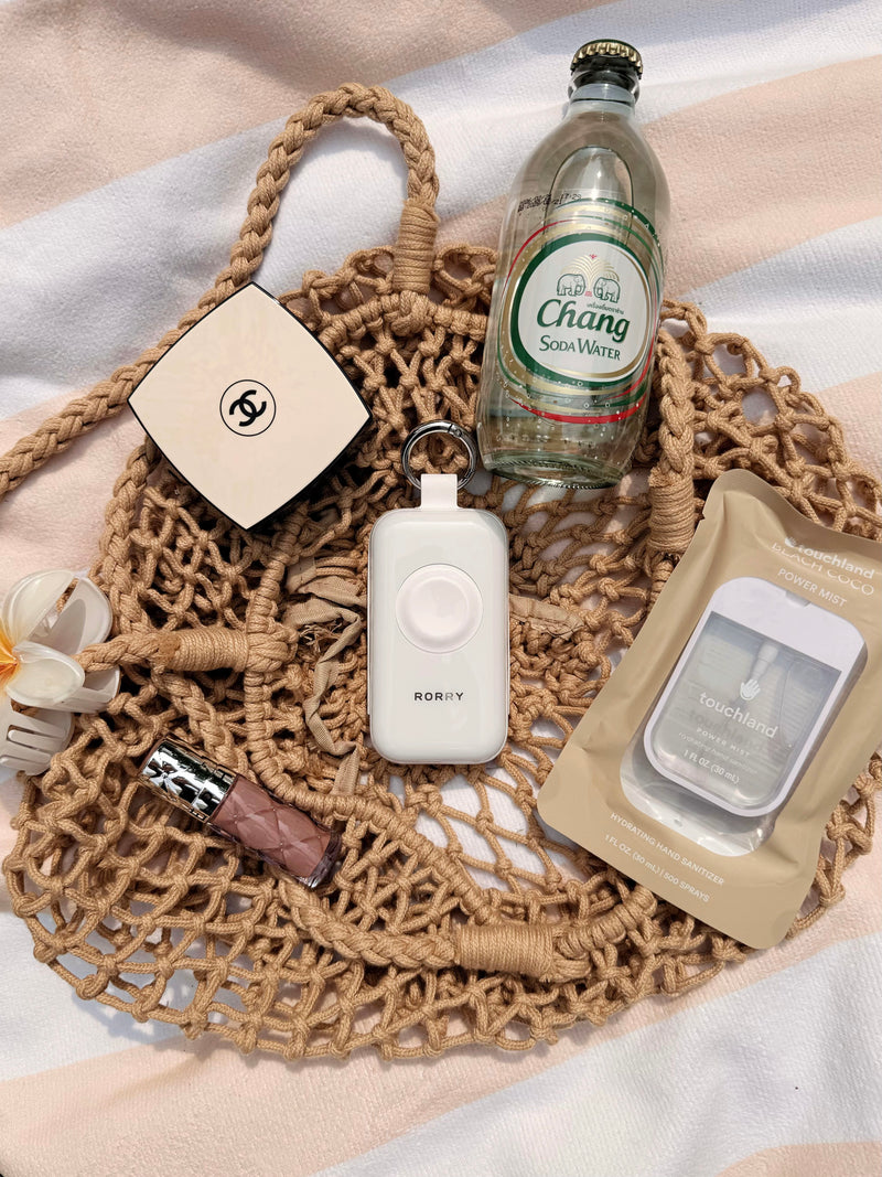 iphone usb c charger in a summer beach bag with beauty and travel accessories