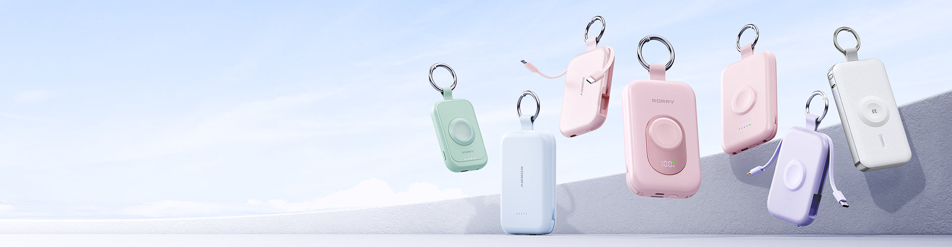Set of colorful portable charger keychain on a light blue background